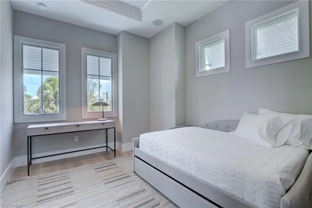 a bedroom with a bed and windows