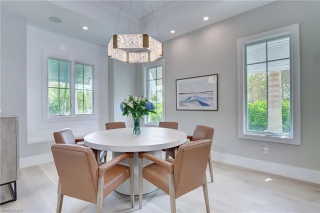 a view of a dining room with furniture a chandelier and wooden floor