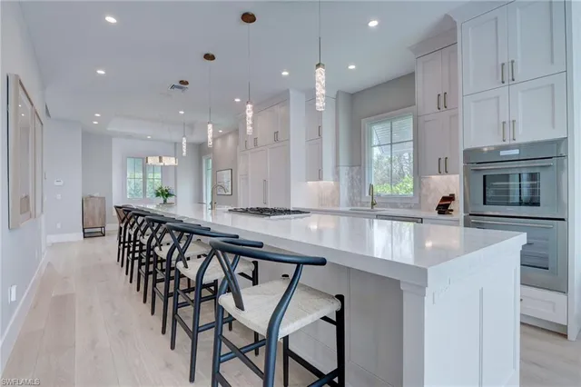 a large kitchen with kitchen island a large island in it