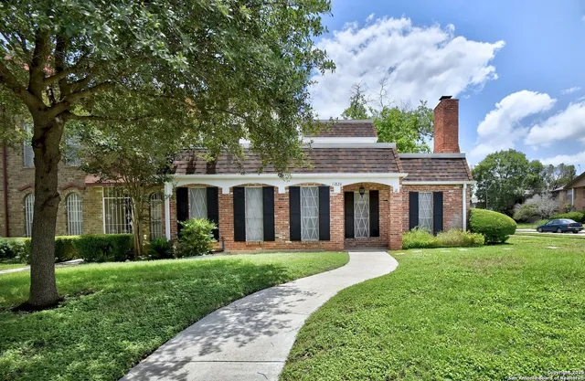 a front view of a house with a yard and trees