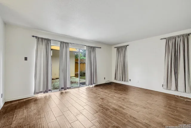 a view of an empty room with wooden floor