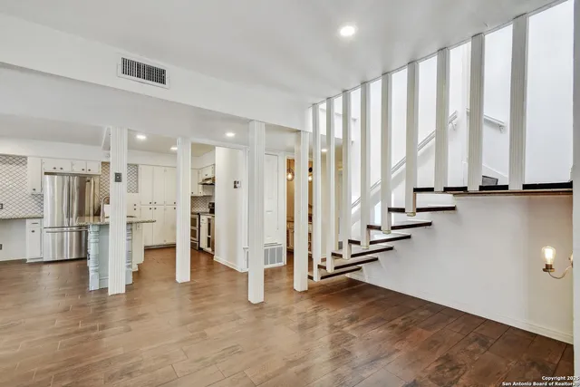 a view of an empty room with a floor to ceiling window and wooden floor