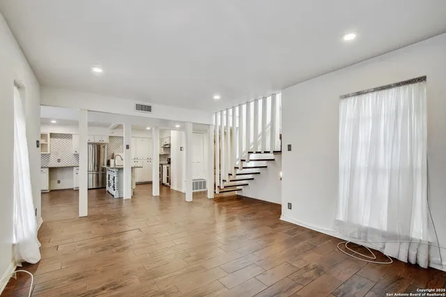 an empty room with wooden floor and a window