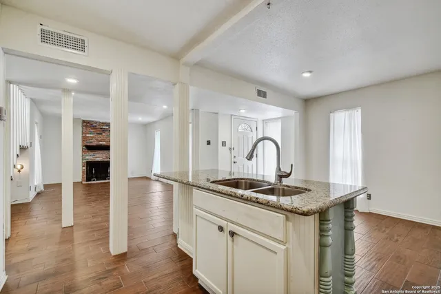 a kitchen with granite countertop a sink and a stove