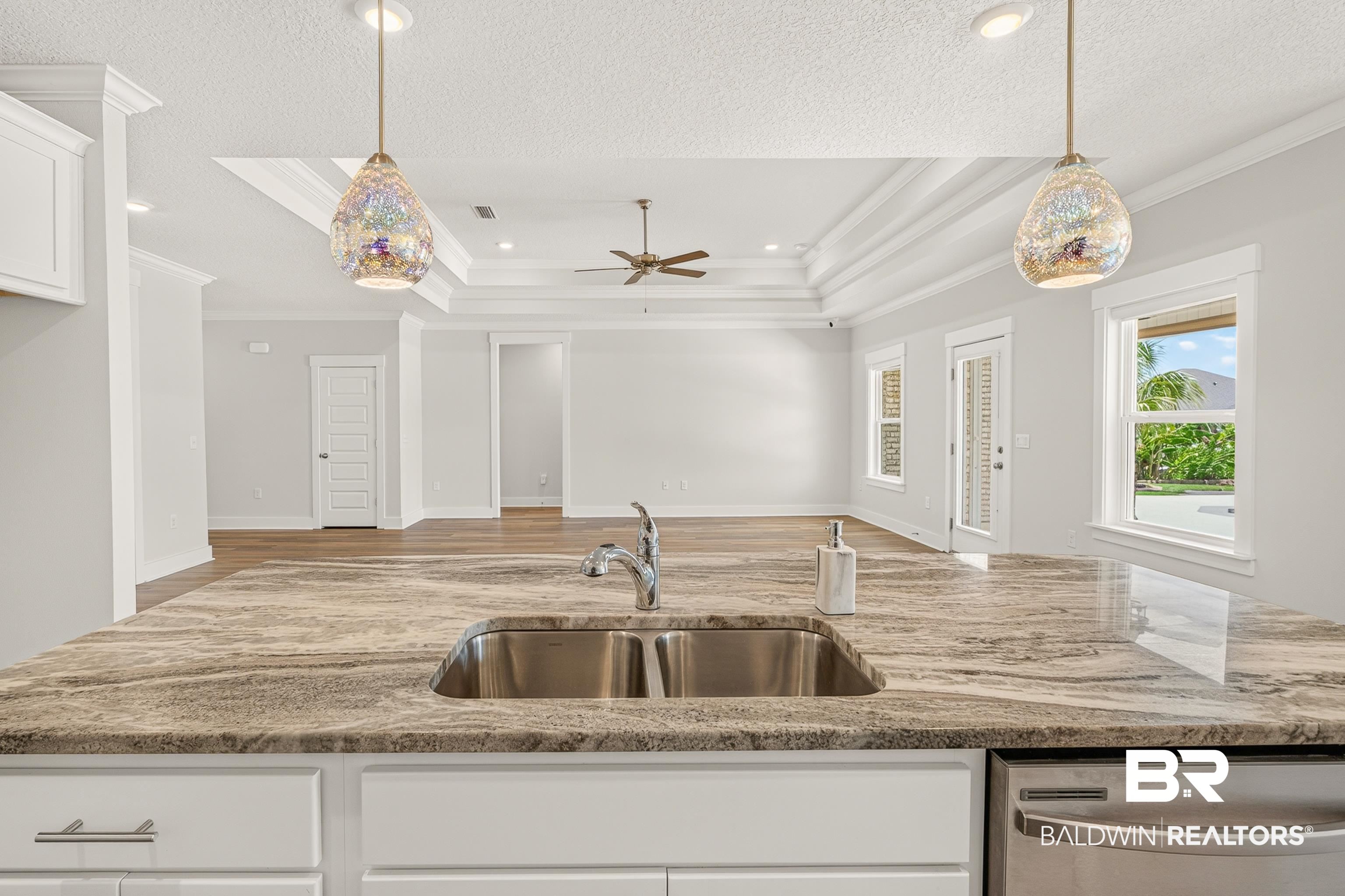 1724 Partridge Street Foley, AL 36535 - Photo 17 of 62 Kitchen island featuring a double basin stainless steel sink, chrome faucet, and expansive countertop
