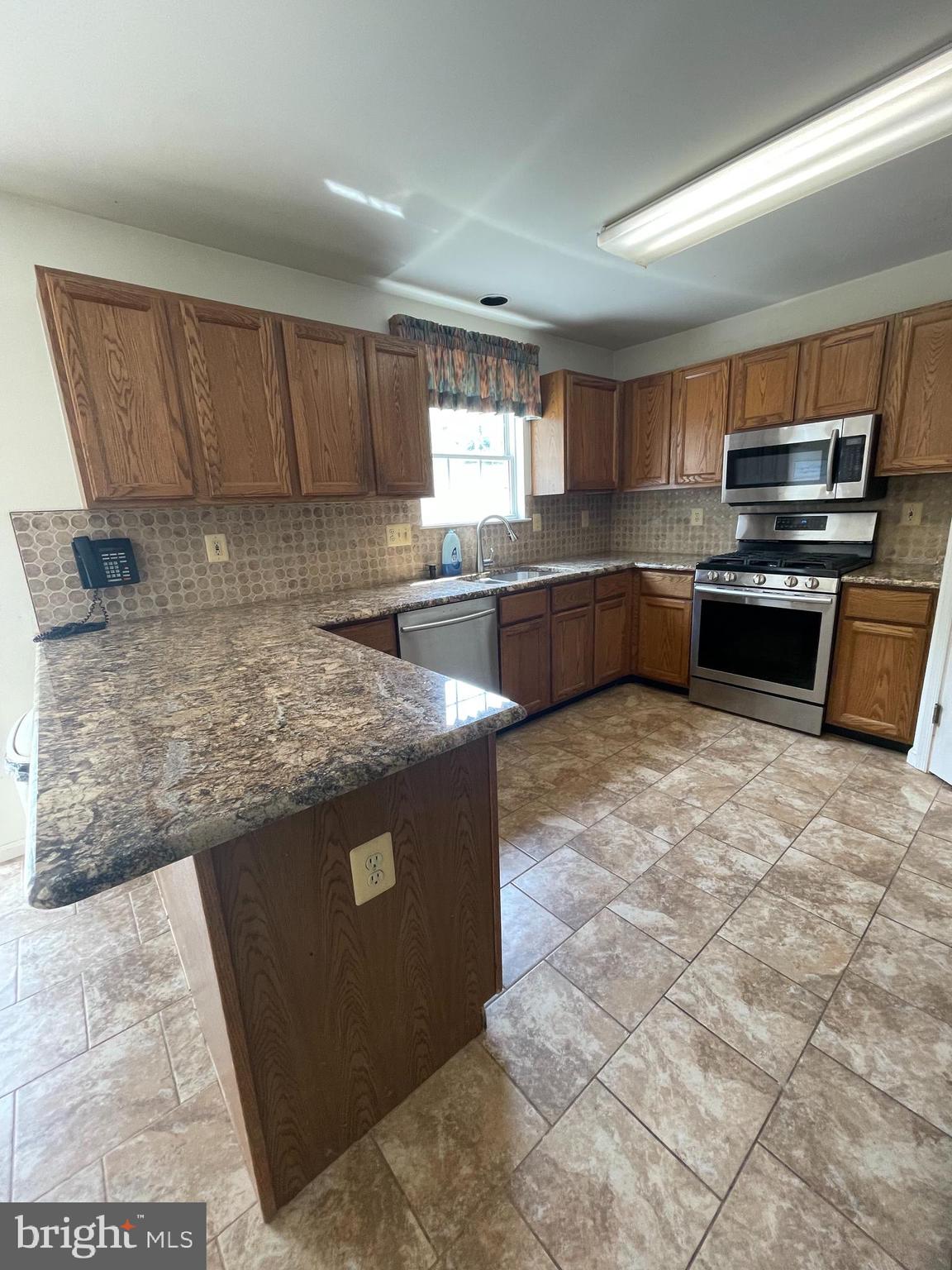 6223 Cliffside Terrace Frederick, MD 21701 - Photo 3 of 18 a kitchen with stainless steel appliances granite countertop a stove a sink and a refrigerator