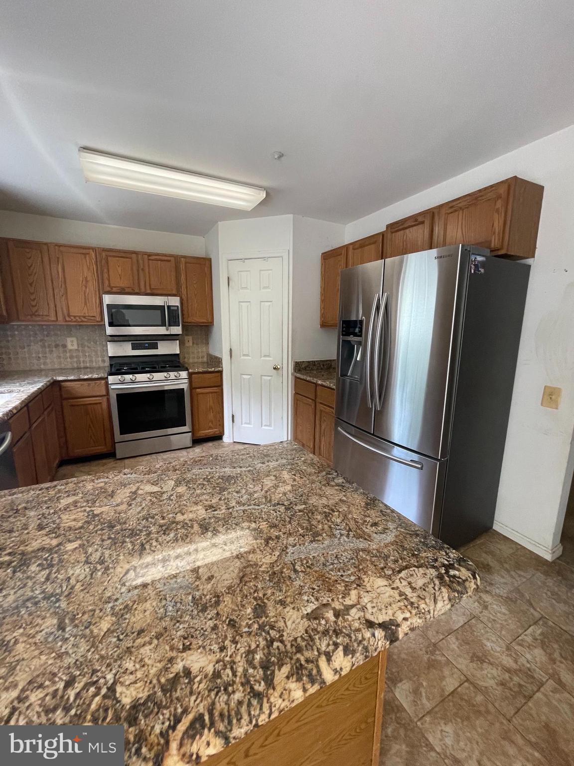 6223 Cliffside Terrace Frederick, MD 21701 - Photo 4 of 18 a kitchen with stainless steel appliances granite countertop a refrigerator and a stove