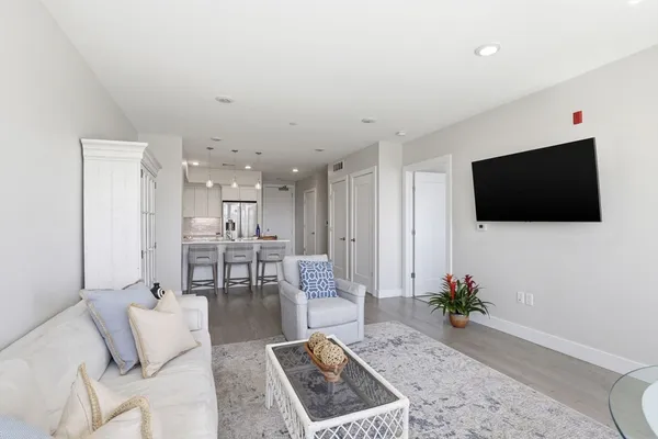a living room with furniture a flat screen tv and a floor to ceiling window