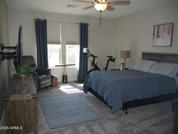 a spacious bedroom with a bed a couch and a chandelier