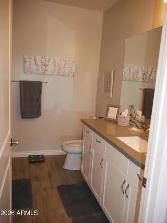 a bathroom with a granite countertop sink a toilet and a mirror