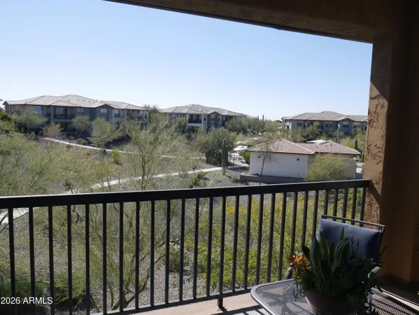 a view of a balcony with wooden floor and fence