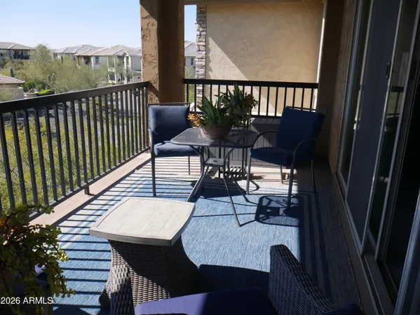 a view of a balcony with chairs and a potted plant