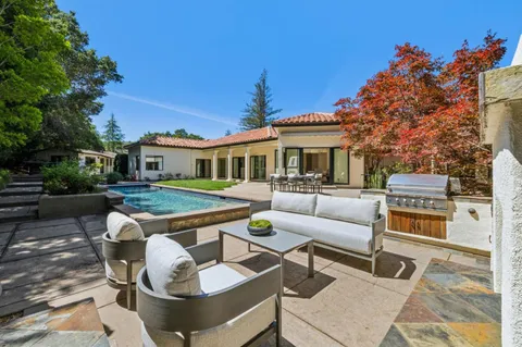 a view of a patio with couches table and chairs and potted plants