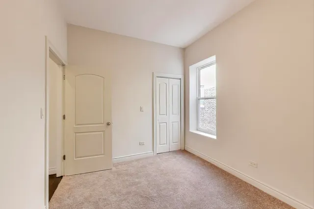 an empty room with windows and closet