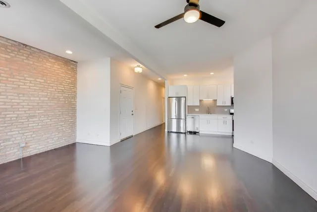 a view of a kitchen with wooden floor and a ceiling fan