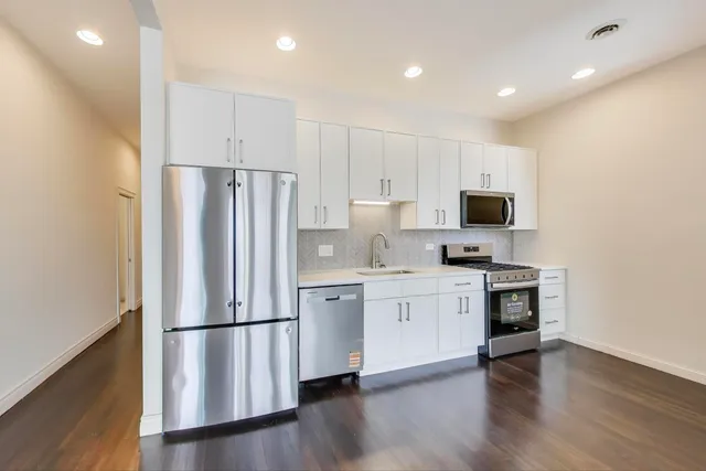 a kitchen with stainless steel appliances a refrigerator stove microwave and cabinets