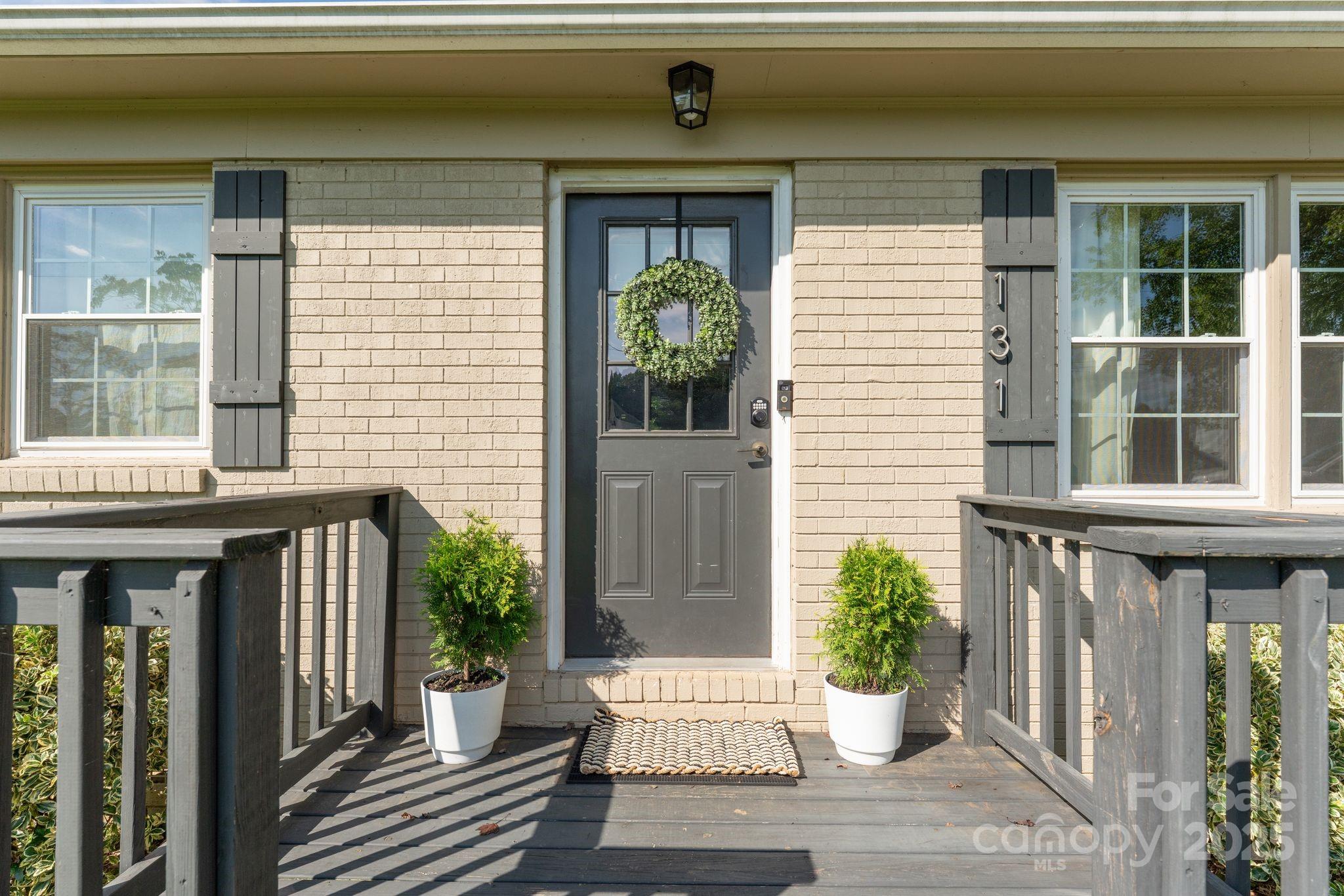 131 Sheffield Road Mocksville, NC 27028 - Photo 3 of 21 a house with potted plants in front of door