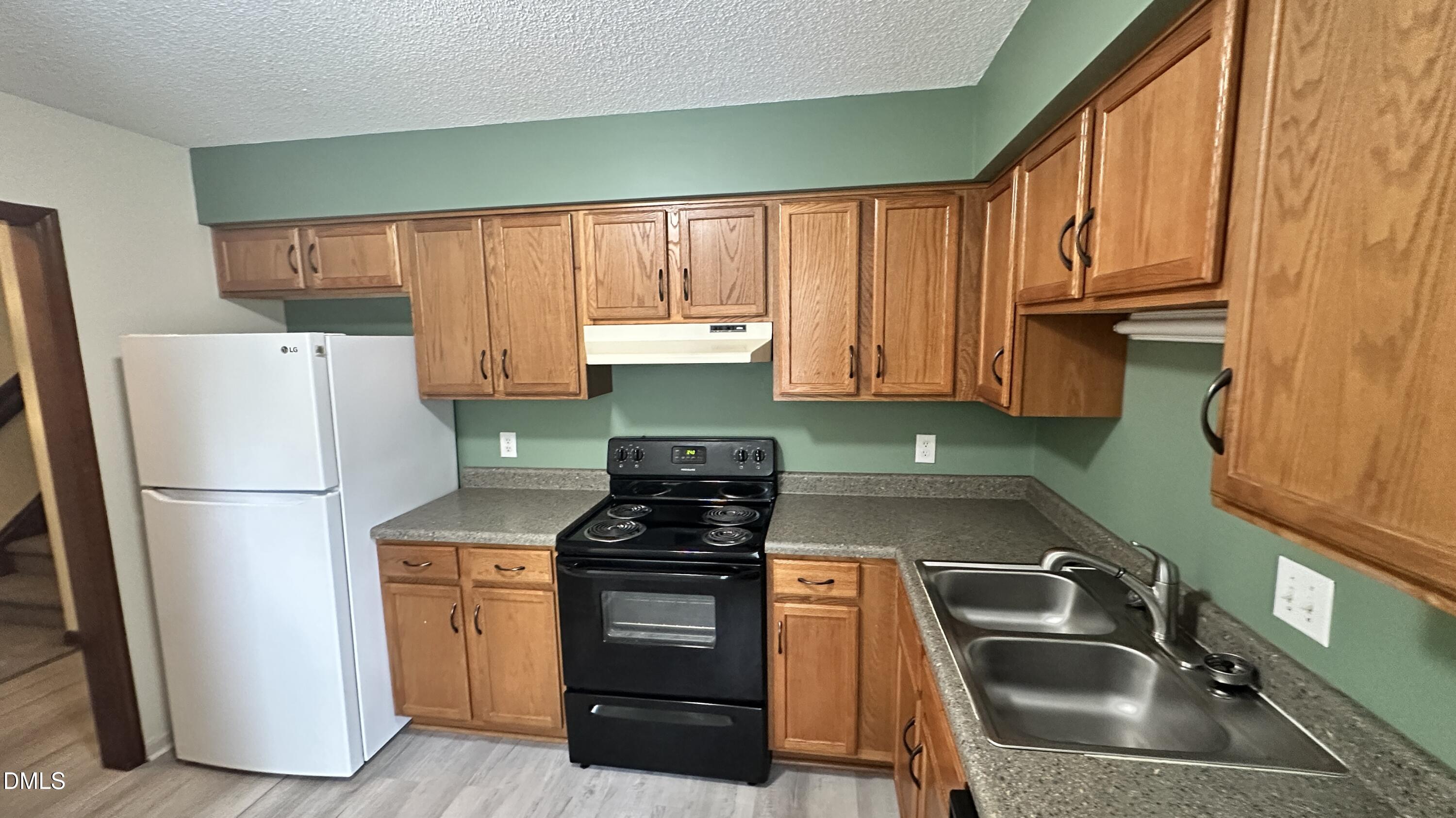 4705 Fargo Court, Unit B Raleigh, NC 27612 - Photo 3 of 9 a kitchen with a refrigerator sink and stove