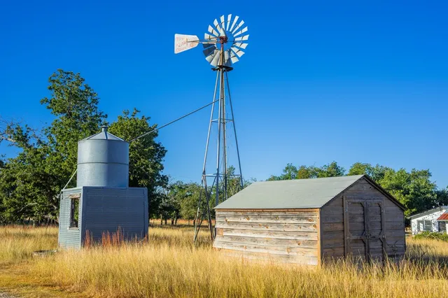 a view of house with swimming pool and a tree