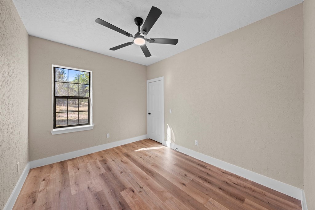 28 Ruger Road Fredericksburg, TX 78624 - Photo 25 of 43 an empty room with wooden floor fan and windows