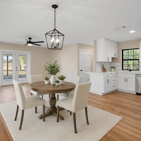 a view of an empty room with a window and kitchen view