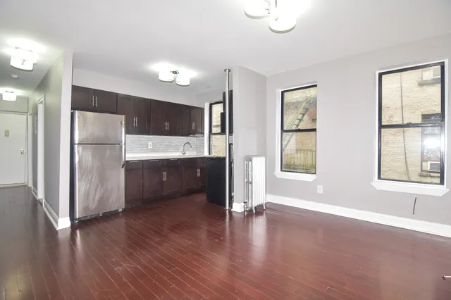 a kitchen with stainless steel appliances a refrigerator and wooden floor