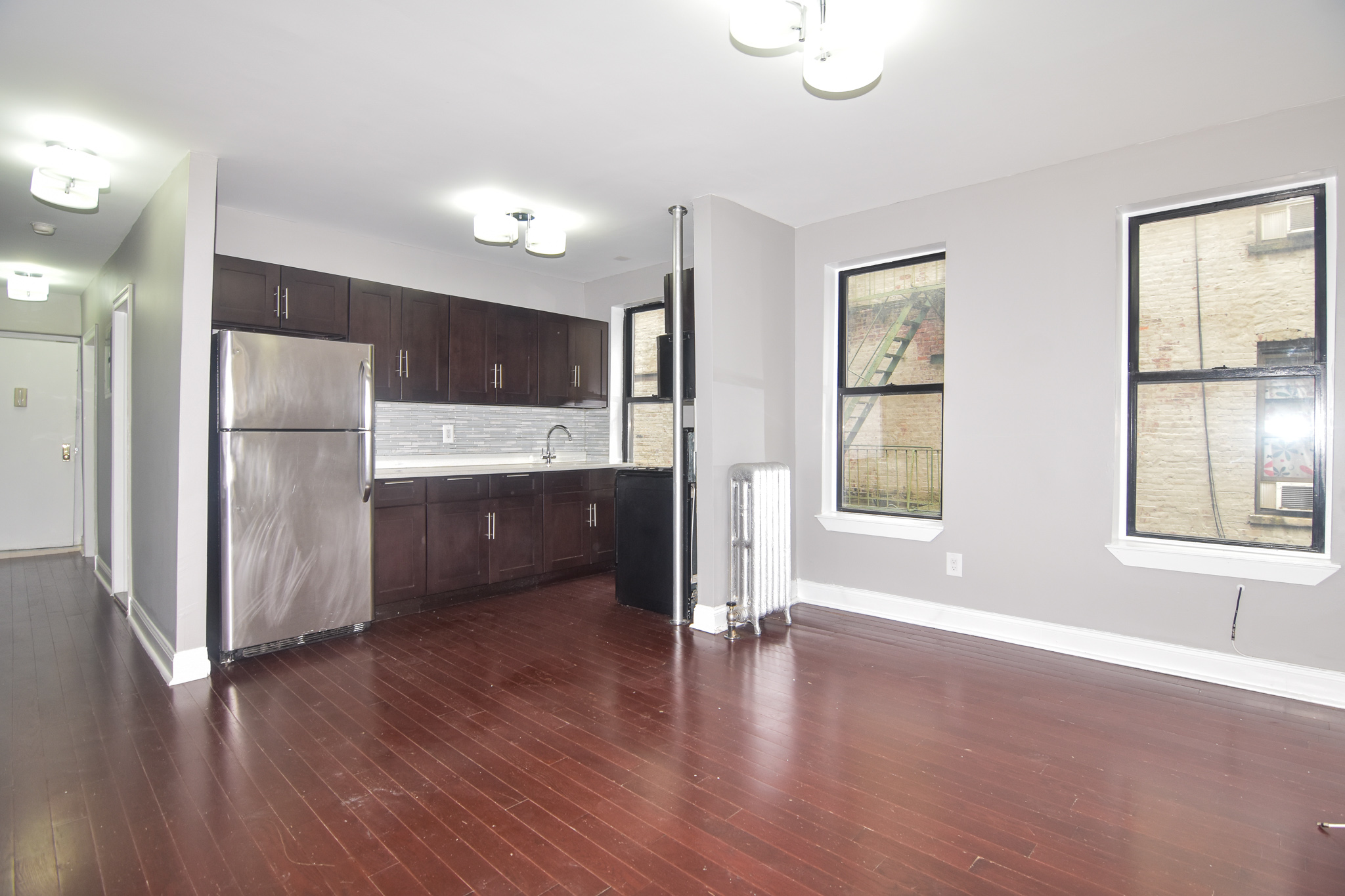 304 West 151st Street, Unit 12A Manhattan, NY 10039 - Photo 5 of 6 a kitchen with stainless steel appliances a refrigerator and wooden floor