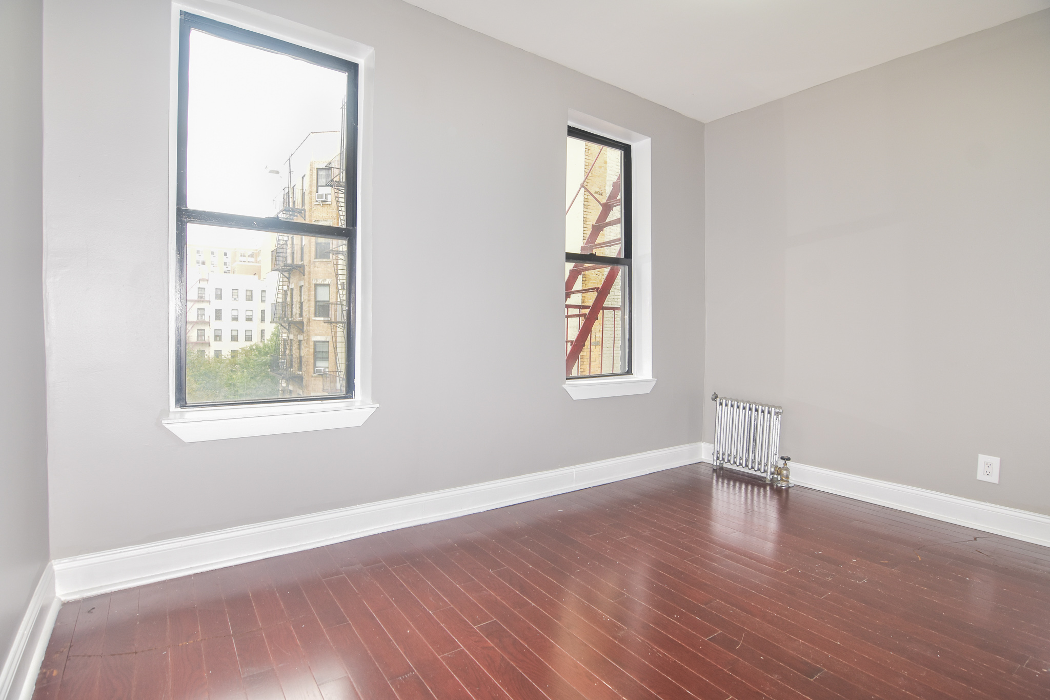 304 West 151st Street, Unit 12A Manhattan, NY 10039 - Photo 6 of 6 an empty room with wooden floor and windows