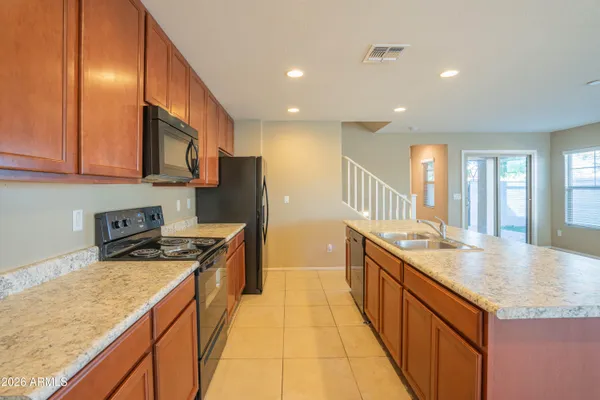 a kitchen with stainless steel appliances granite countertop a sink a stove and a wooden floors
