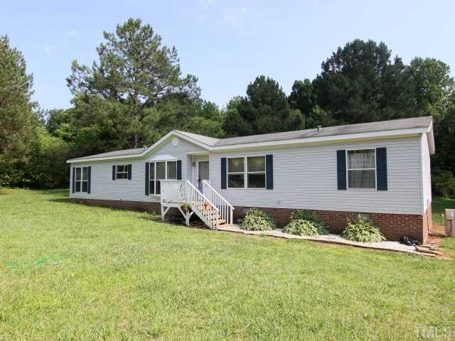 a front view of a house with a garden and yard