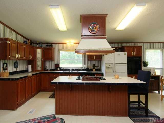 4902 West Ten Road Efland, NC 27243 - Photo 11 of 25 a kitchen with stainless steel appliances granite countertop a sink stove and refrigerator