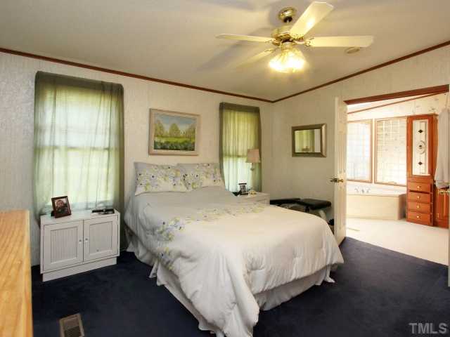 4902 West Ten Road Efland, NC 27243 - Photo 14 of 25 a bedroom with a bed and a chandelier