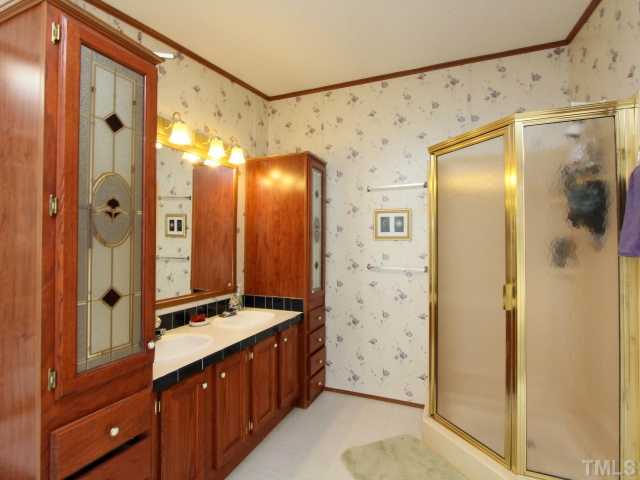 4902 West Ten Road Efland, NC 27243 - Photo 15 of 25 a bathroom with a glass shower door and a sink