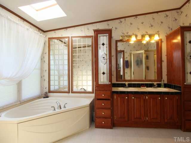 4902 West Ten Road Efland, NC 27243 - Photo 16 of 25 a bathroom with a tub a sink and mirror