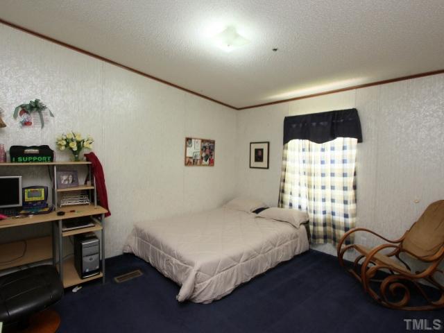 4902 West Ten Road Efland, NC 27243 - Photo 17 of 25 a bedroom with a bed and a chair