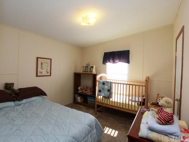 4902 West Ten Road Efland, NC 27243 - Photo 18 of 25 a bedroom with a bed and a couch