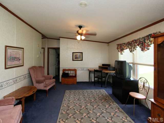 4902 West Ten Road Efland, NC 27243 - Photo 4 of 25 a living room with furniture a fireplace and a table