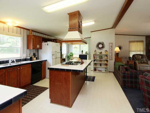4902 West Ten Road Efland, NC 27243 - Photo 9 of 25 a large kitchen with stainless steel appliances a stove a sink dishwasher and cabinets with wooden floor