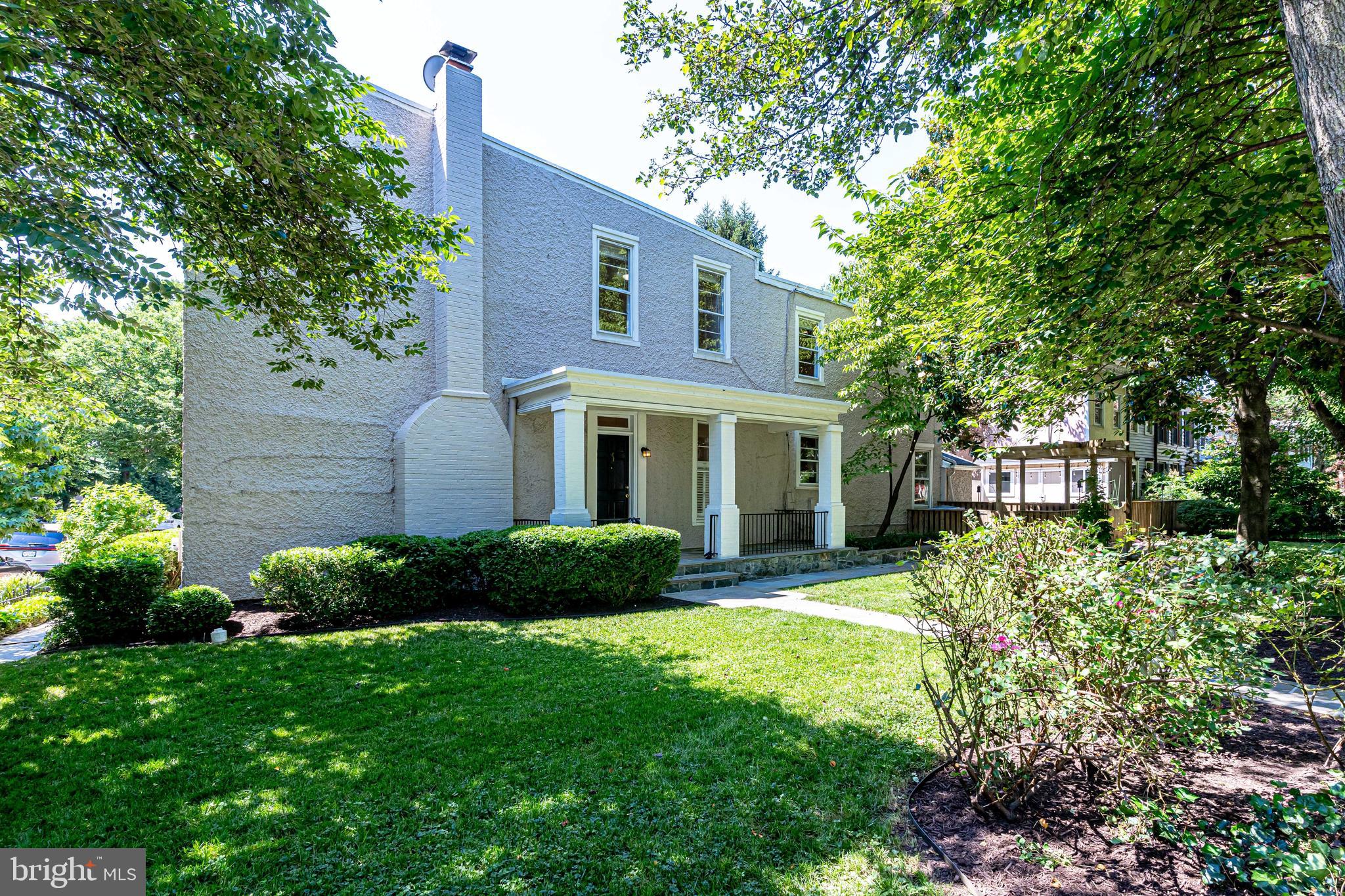 a front view of a house with a garden and plants