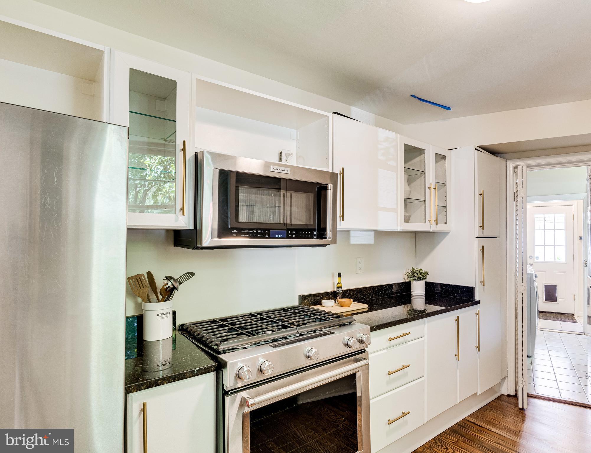 329 11th Street Southeast Washington, DC 20003 - Photo 13 of 49 a kitchen with stainless steel appliances granite countertop a stove a microwave and a refrigerator