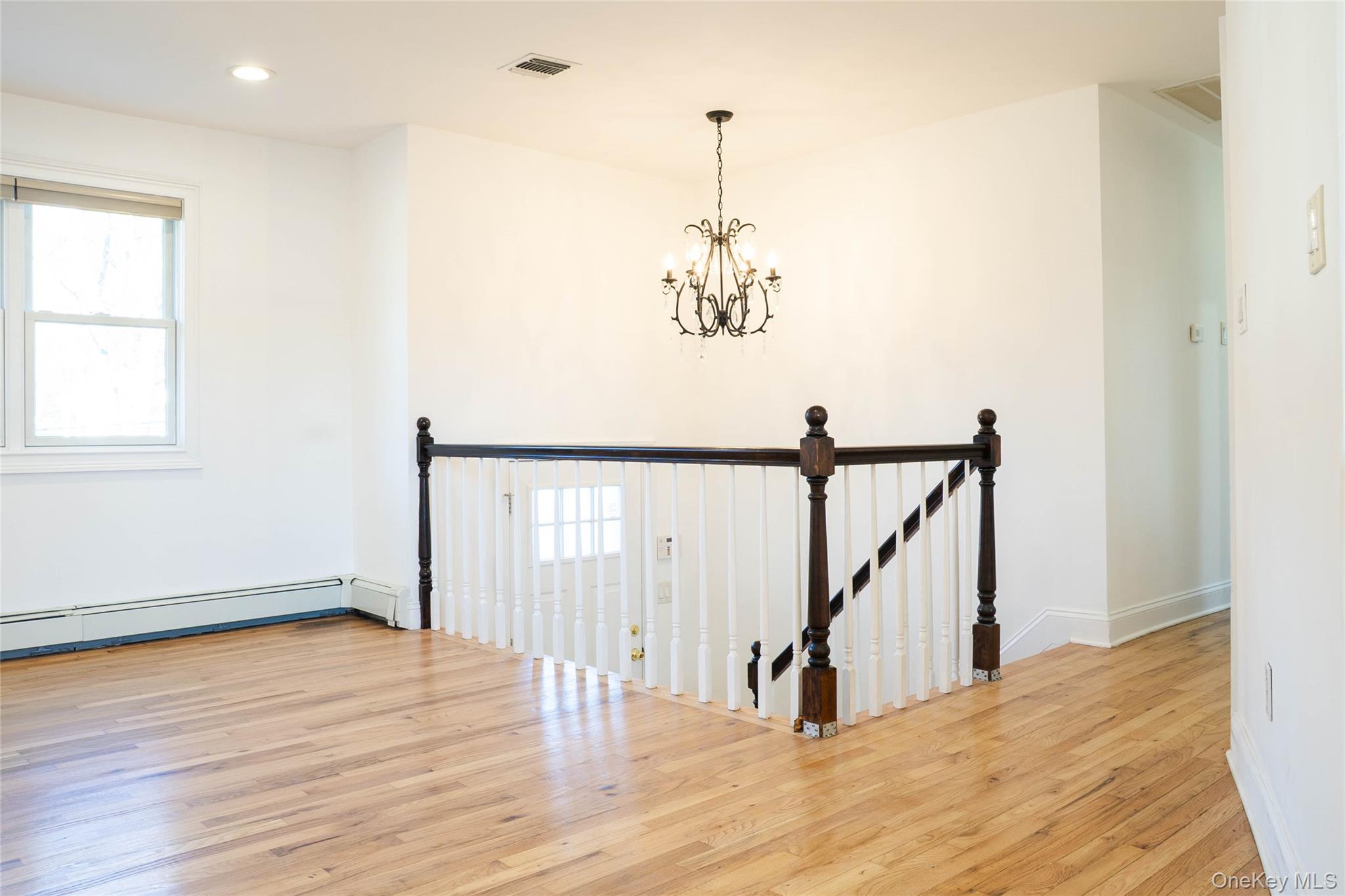58 Hauppauge Road Hauppauge, NY 11788 - Photo 12 of 34 Empty room with healthy amount of natural light, light wood-style flooring, a chandelier, and recessed lighting
