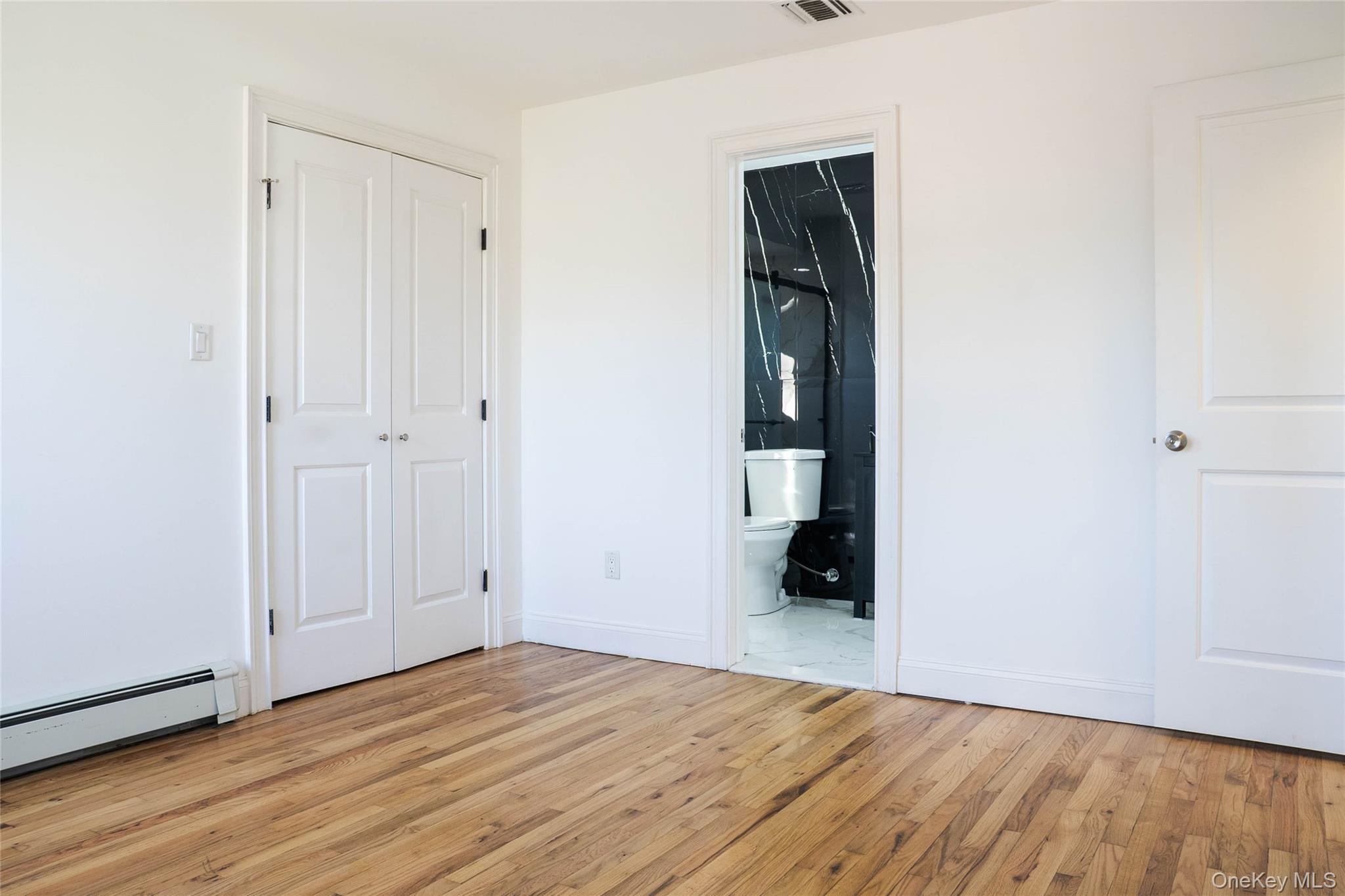 58 Hauppauge Road Hauppauge, NY 11788 - Photo 14 of 34 Unfurnished bedroom with ensuite bath, light wood-type flooring, and a closet
