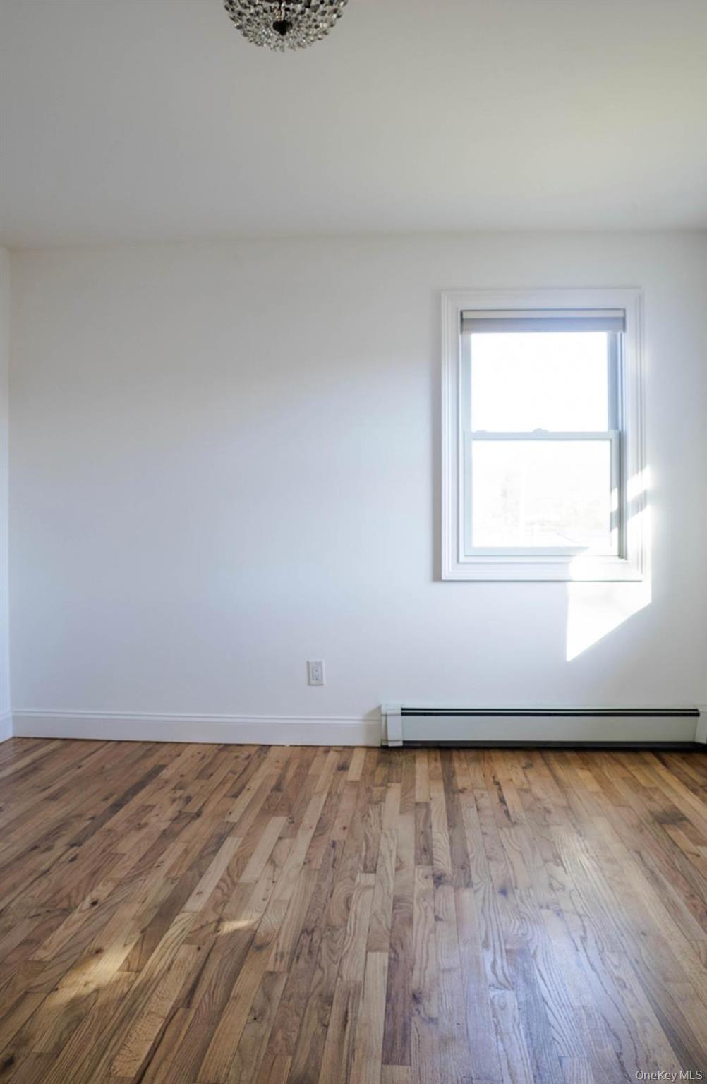 58 Hauppauge Road Hauppauge, NY 11788 - Photo 16 of 34 Unfurnished room with wood-type flooring and baseboard heating