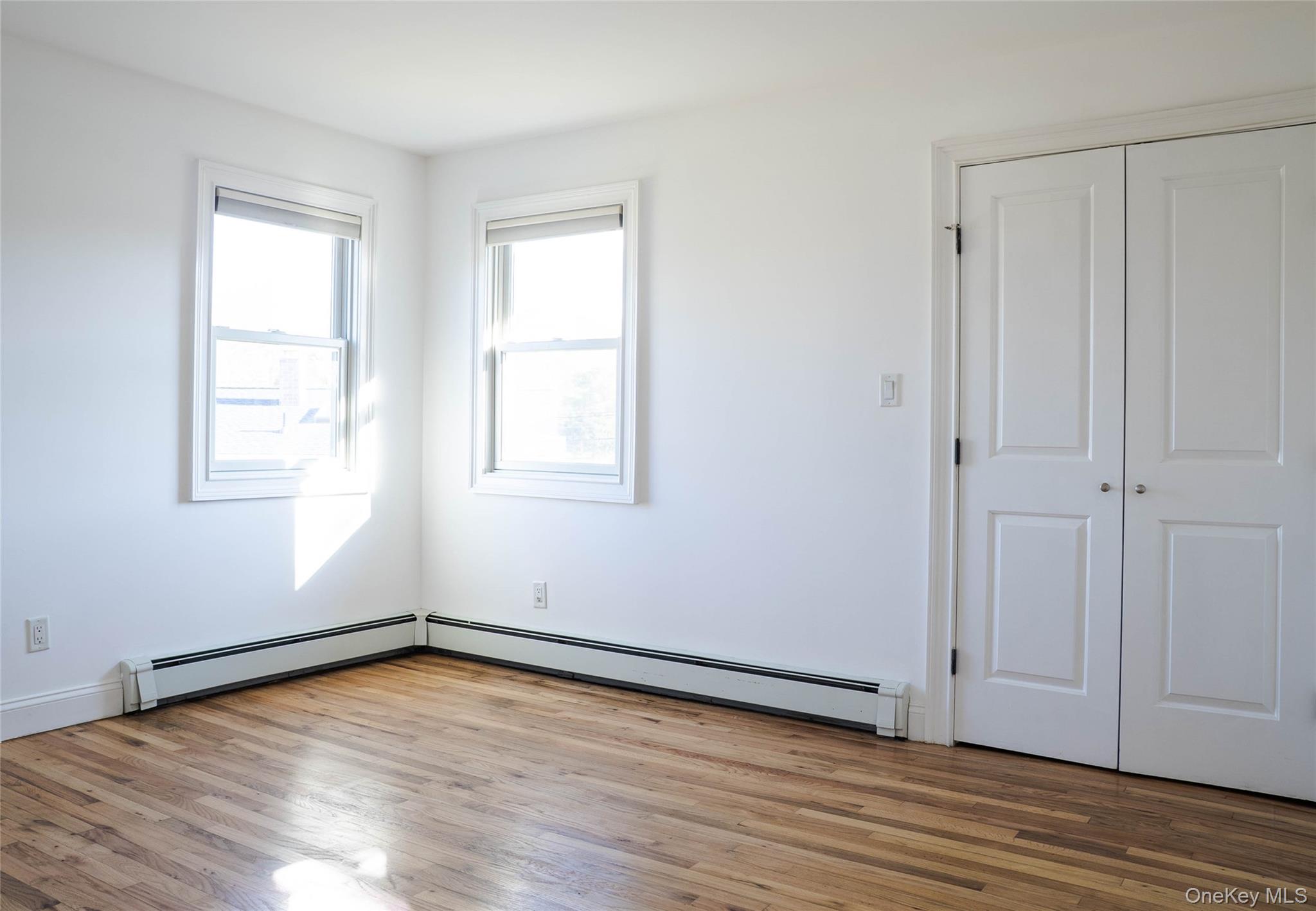 58 Hauppauge Road Hauppauge, NY 11788 - Photo 17 of 34 Unfurnished bedroom with light wood-style floors, a baseboard radiator, and a closet