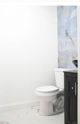 a white toilet sitting next to a white sink