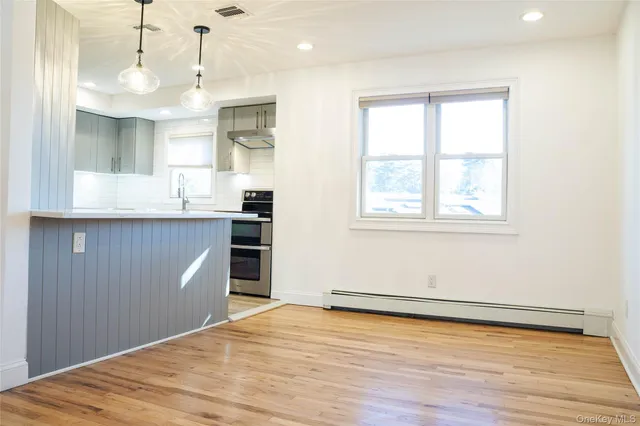 a view of a kitchen with wooden floor and a window