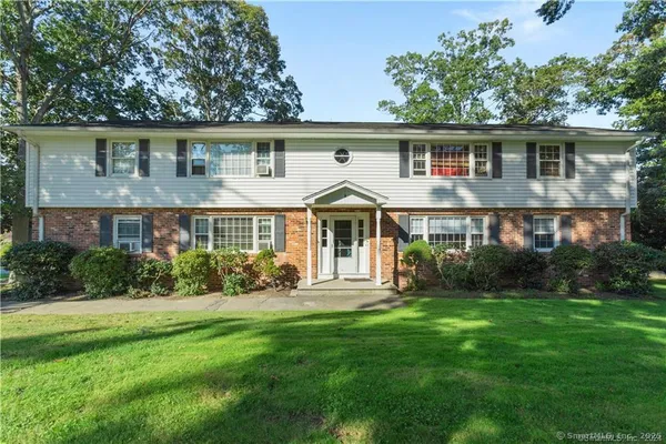 a front view of a house with a yard and green space