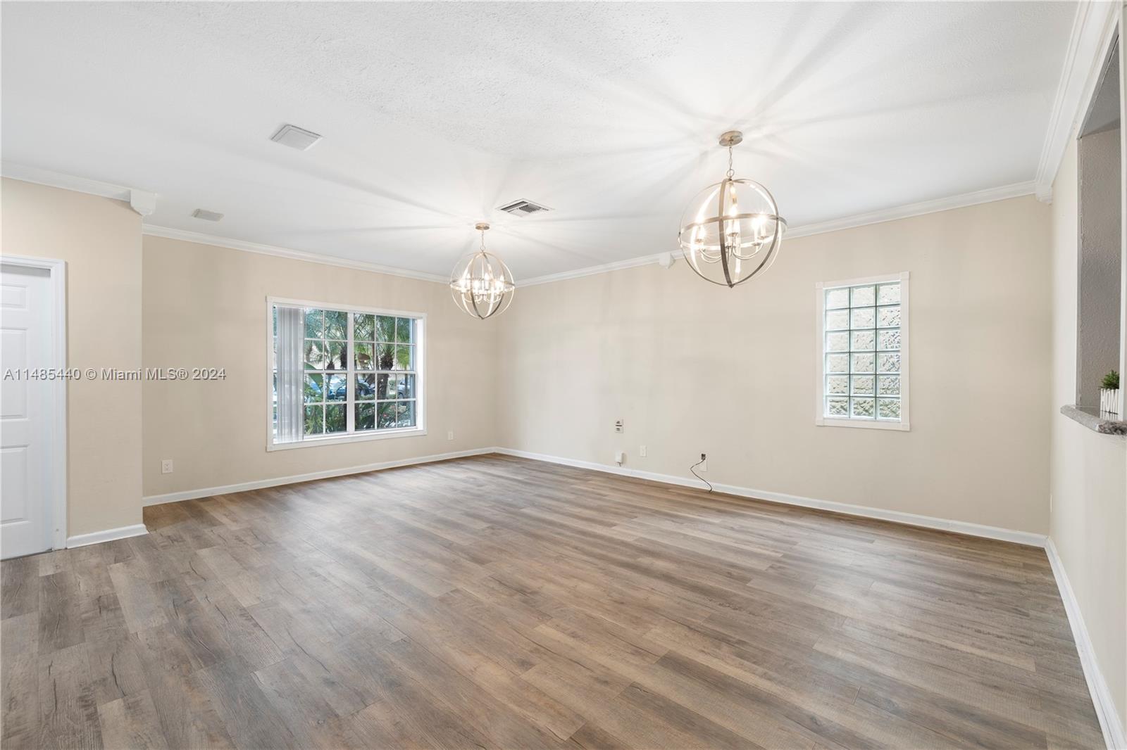 16225 Emerald Cove Road, Unit 16225 Weston, FL 33331 - Photo 2 of 26 an empty room with wooden floor chandelier and windows