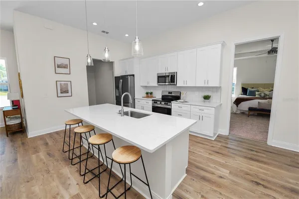 a large white kitchen with stainless steel appliances
