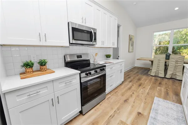 a kitchen with white cabinets and stainless steel appliances